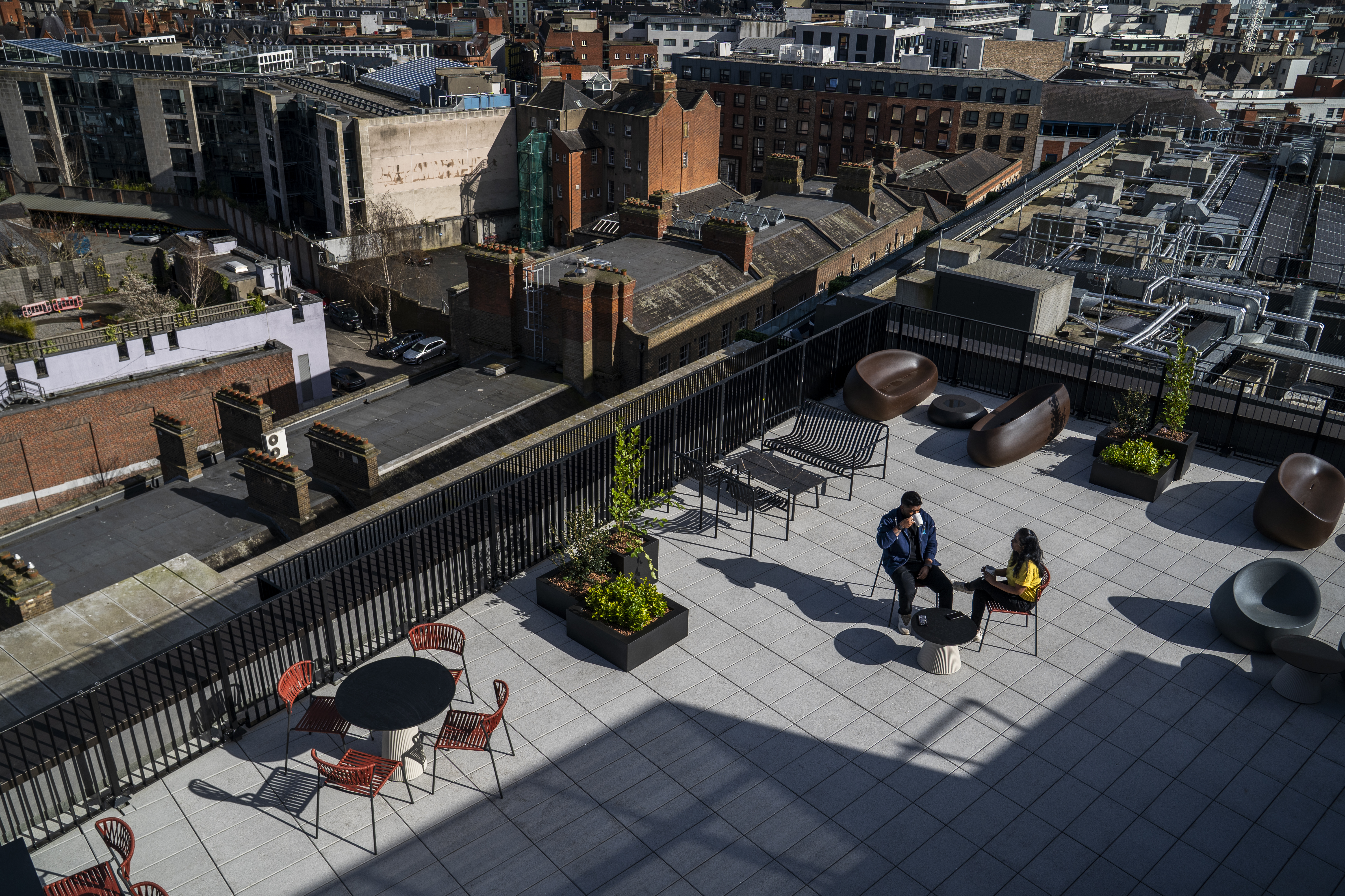 Employees sitting on a rooftop terrace overlooking Dublin city.