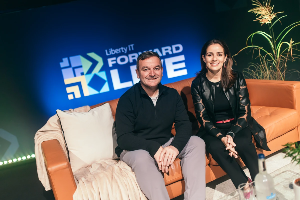 Tony and Monica smiling on stage with Forward Live logo behind them