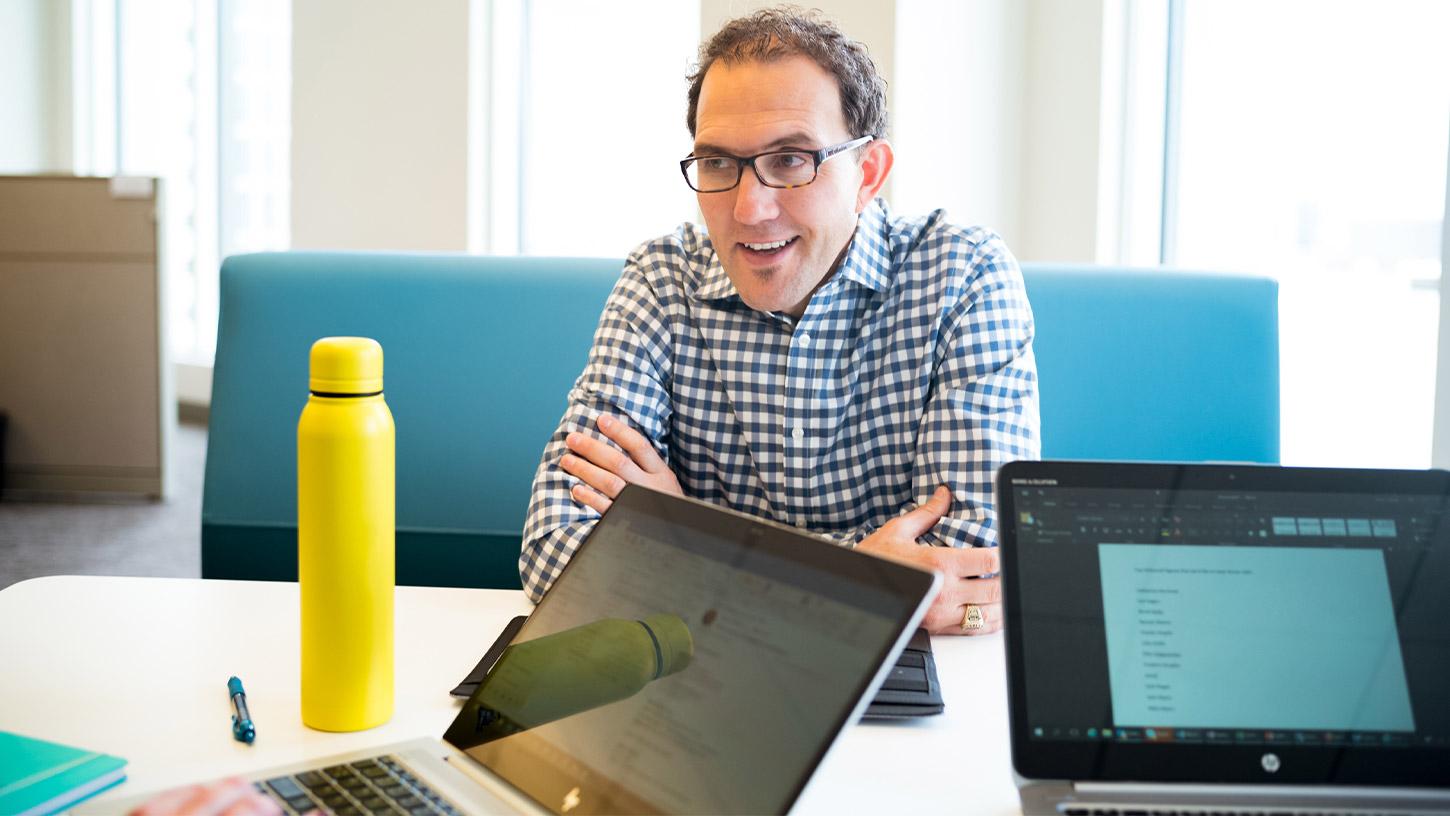 Image of a man facing two laptop screens