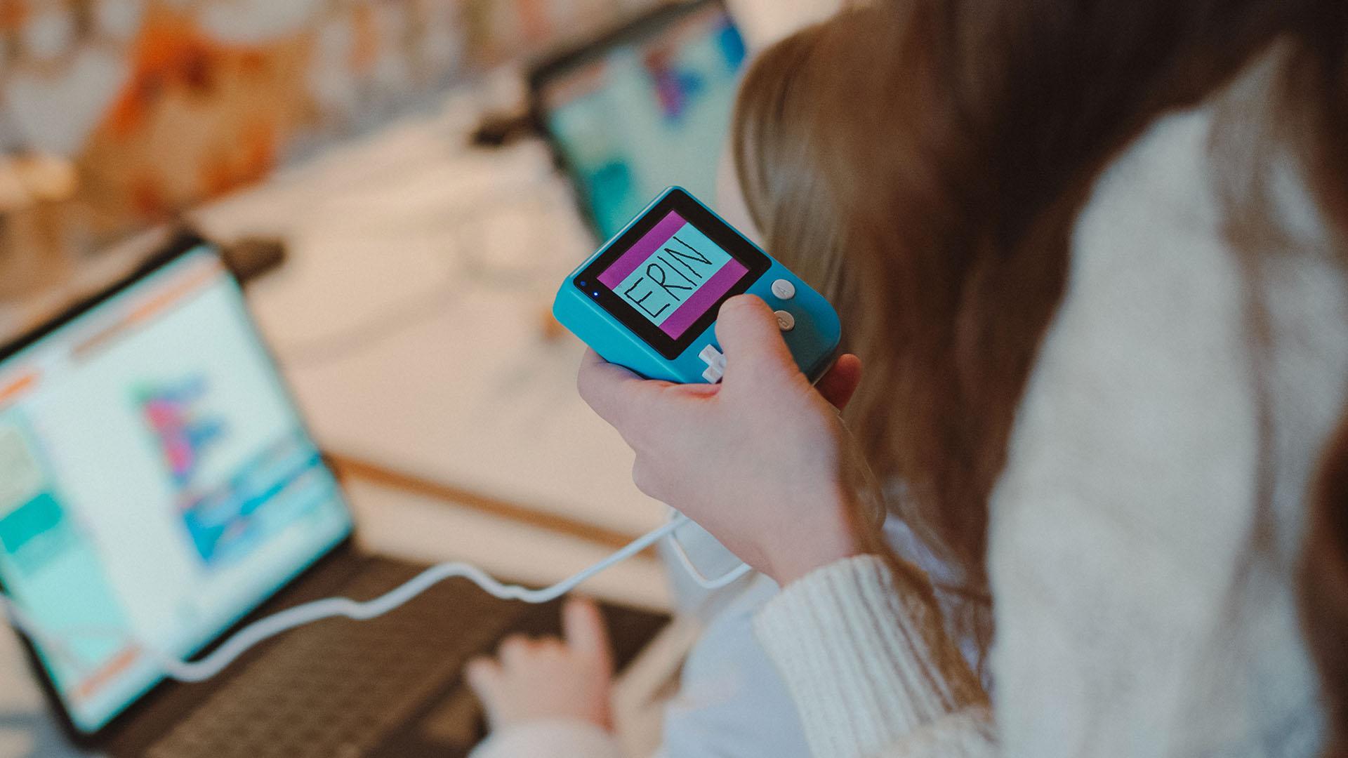 (slide 8 of 9) A schoolchild working with a Microsoft MakeCode Arcade device. 